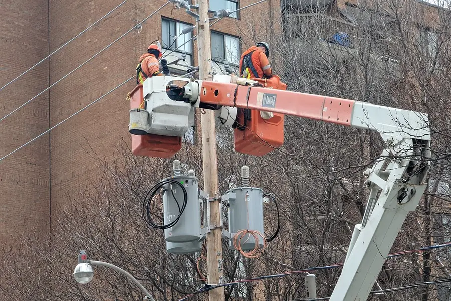 Line crew replacing pole-mounted transformers from bucket trucks